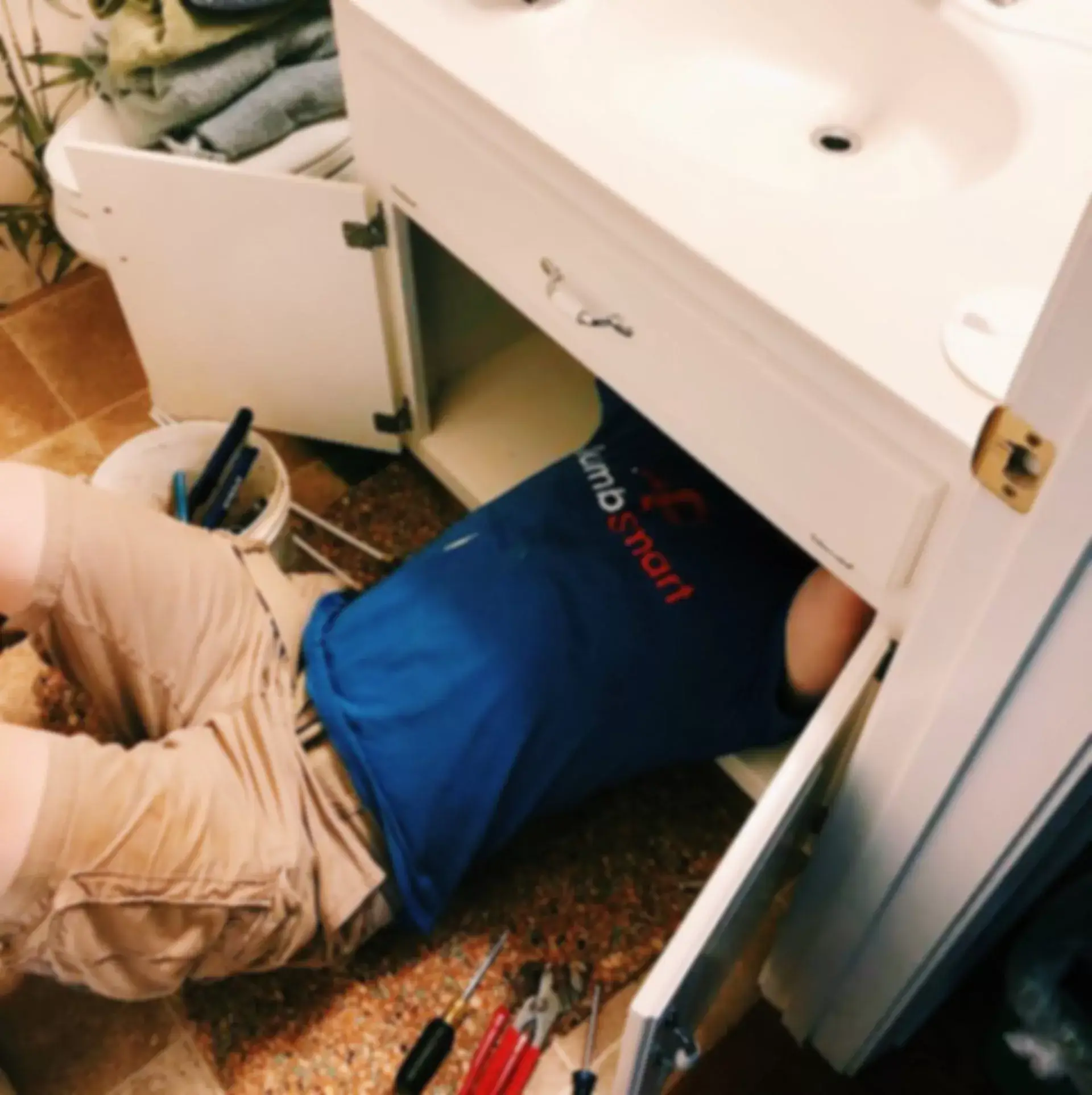 A Plumb Smart plumber fixing a gurgling sink.