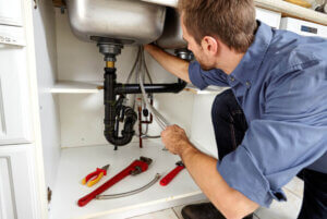 Plumber fixing leak